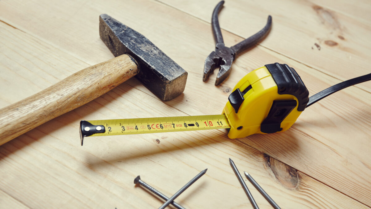 outils de rénovation alignés sur un plan de travail de cuisine en bois avec marteau
